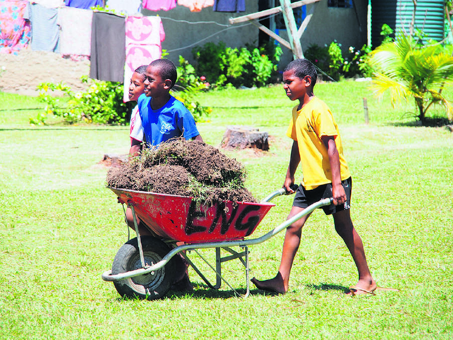 HELPING HANDS – Conua schoolchildren do their bit by bringing in turf to cover the grounds around the  kindergarten.