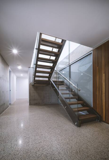 Sunlight floods through the entryway and heats up the concrete. The stairwell is the main circulation area. It features a glass wall and connects the whole house.