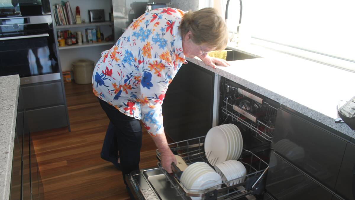 Lynne demonstrates how her dishwasher drawer is pulled out and then raised to make dishes more accessible. Photo: Ellouise Bailey