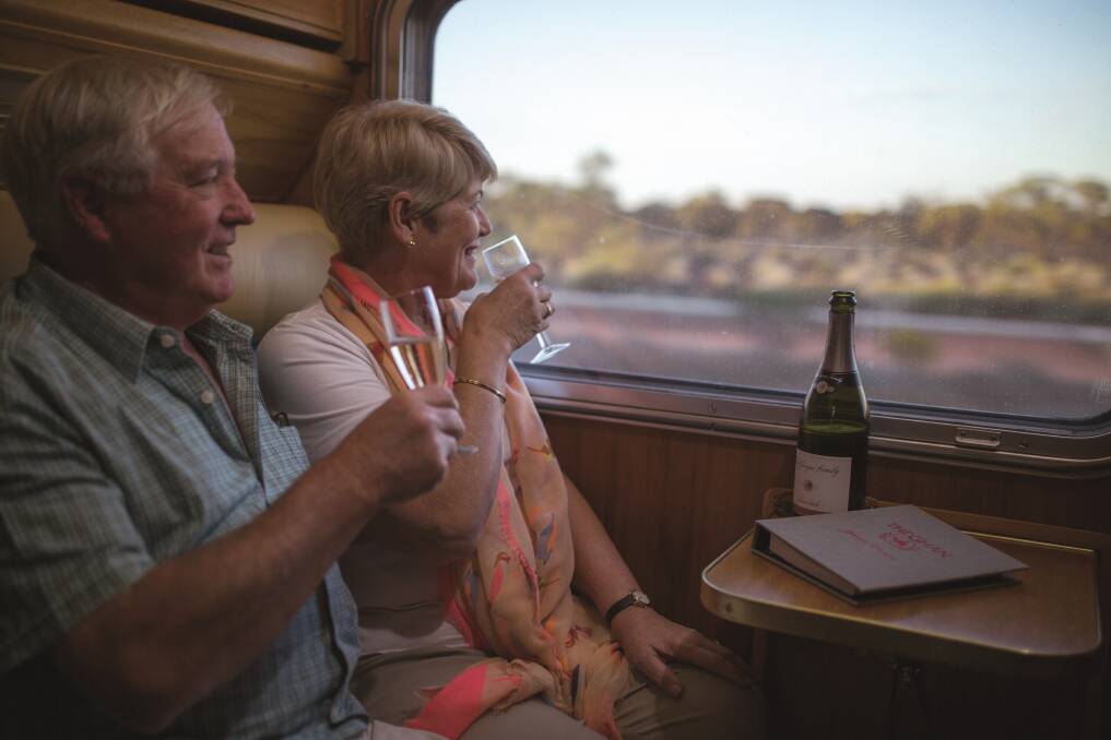 Travellers aboard The Ghan take in the view of the Red Centre from the comfort of their cabin. Picture supplied by Holidays of Australia.