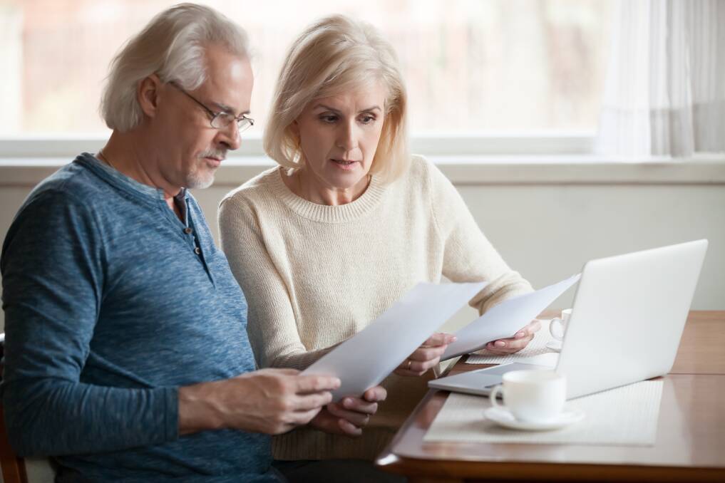 A senior-aged couple analysing paperwork. Shutterstock picture