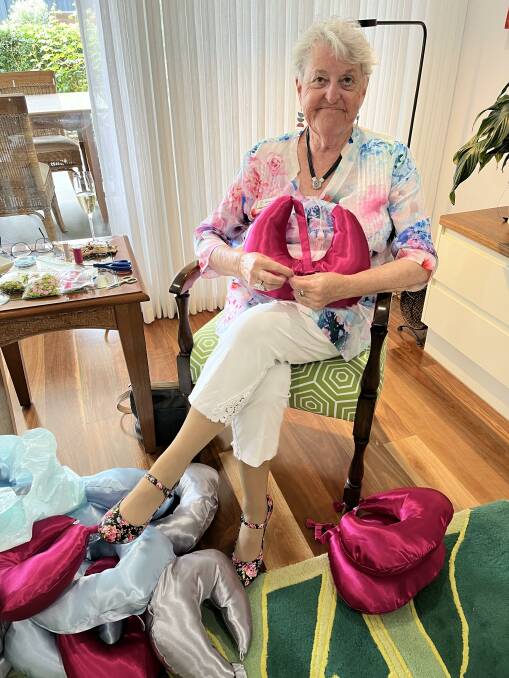 Zonta Club of Adelaide Torrens volunteer Shirley Lamb with one of the cushions, ready to be wrapped up. Picture supplied. 