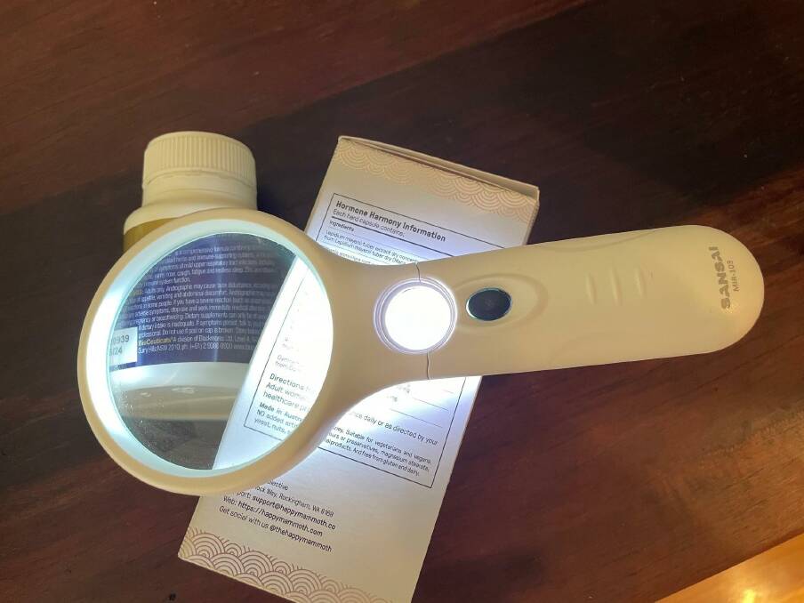 Products like this magnifying glass with a light can help make small writing on medical packaging more legible. ACM file picture