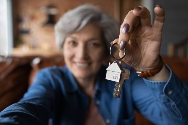 Pictured is a senior woman holding a set of house keys. Shutterstock picture.