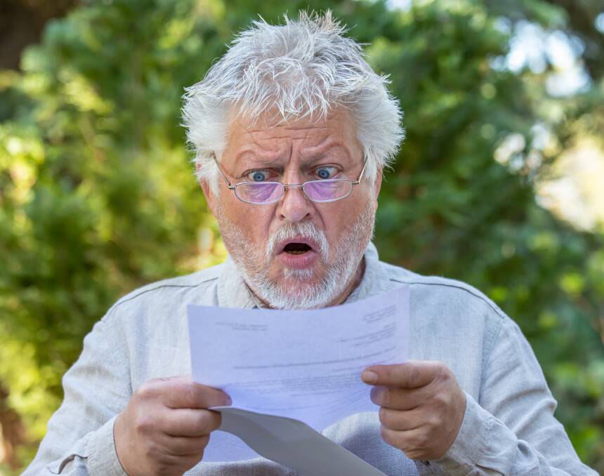 Consumer advocacy group Choice says shopping around and some simple habit changes could save you thousands in 2024. Pictured is a man reading a bill. Shutterstock picture