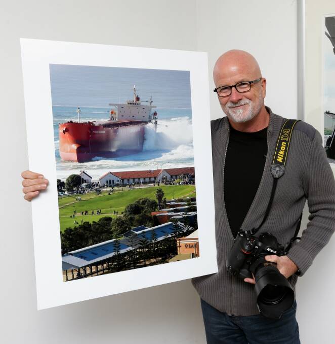 Picture Perfect: Murray McKean with his iconic photograph of the Pasha Bulker, which has been viewed millions of times. Picture: Jonathan Carroll 