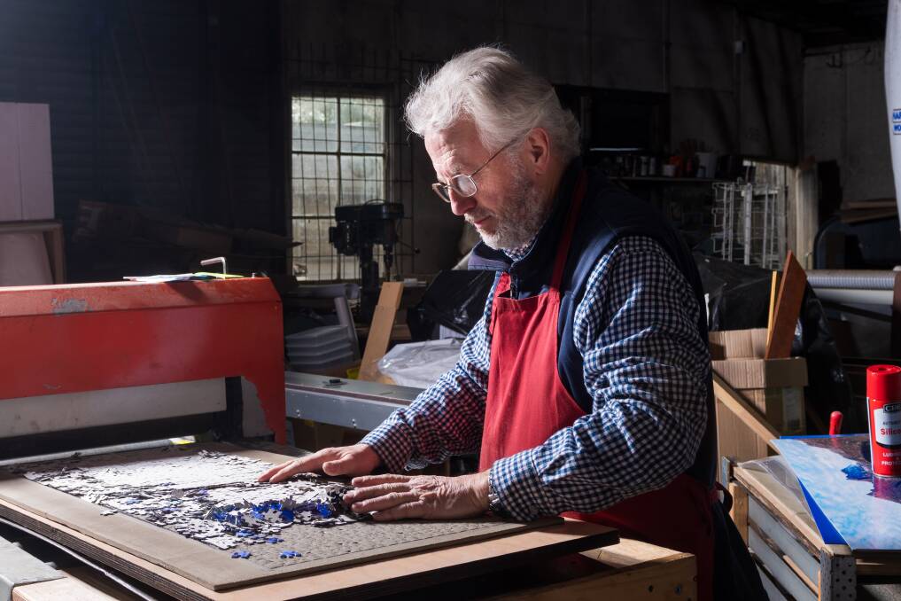 Photographer and puzzle maker John Temple has a cutter to produce 1000-piece jigsaws. Picture: Phillip Biggs