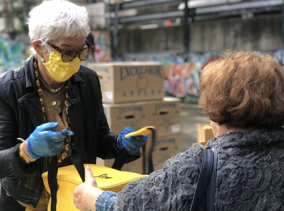 Ronni Kahn handing out free food hampers from an OzHarvest pop-up hamper hub in Sydney's Waterloo.