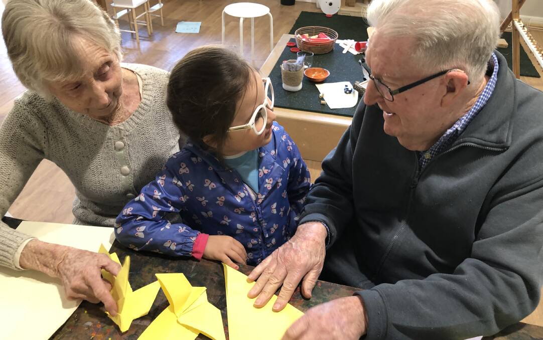 WATCH AND LEARN: Peter Swain and Irene Varley from Peninsula Villages get tips on how to make paper aeroplanes from a young aviation expert from Wallaby Street Early Learning Centre. 