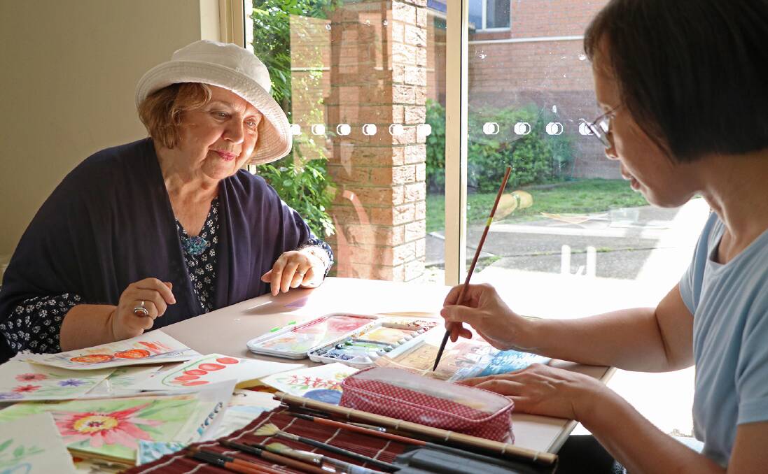 Artist Dorina Petre gives a watercolour class with participant Phyllis. Photo: Jack Doherty