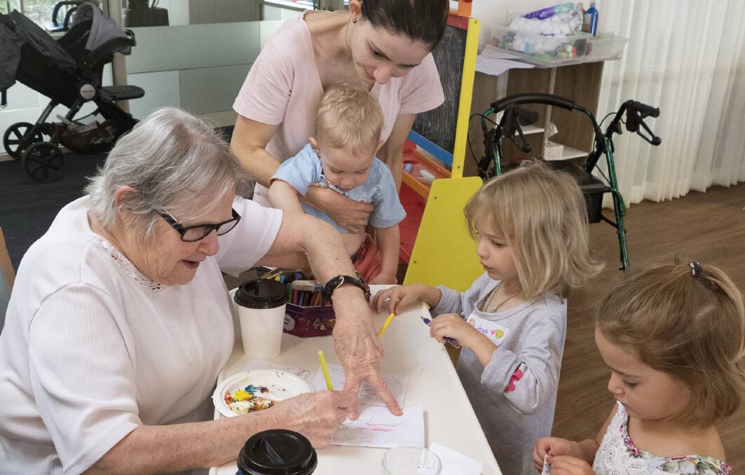 CHILD'S PLAY: Eldercare Evanston Park resident Natalie Lucas draws with children Cooper, Anya and Holly. They are all part of the Little Elders playgroup run by Playgroups SA and aged care provider Eldercare.
