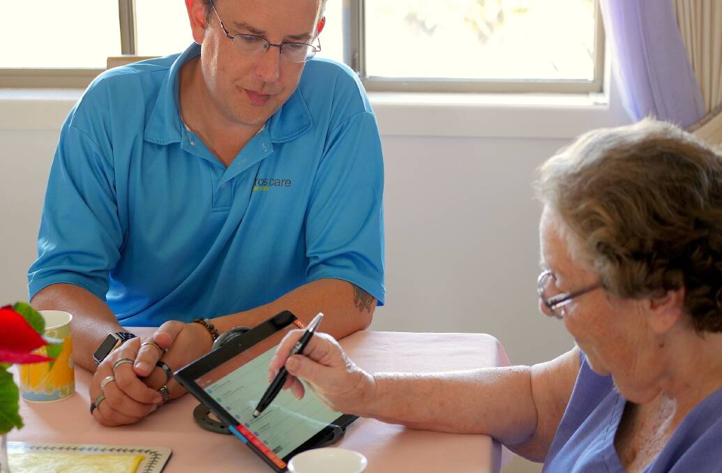 Feros Care Technical Support Officer Russ Hargreaves teaching Edith Neumann to use technology.