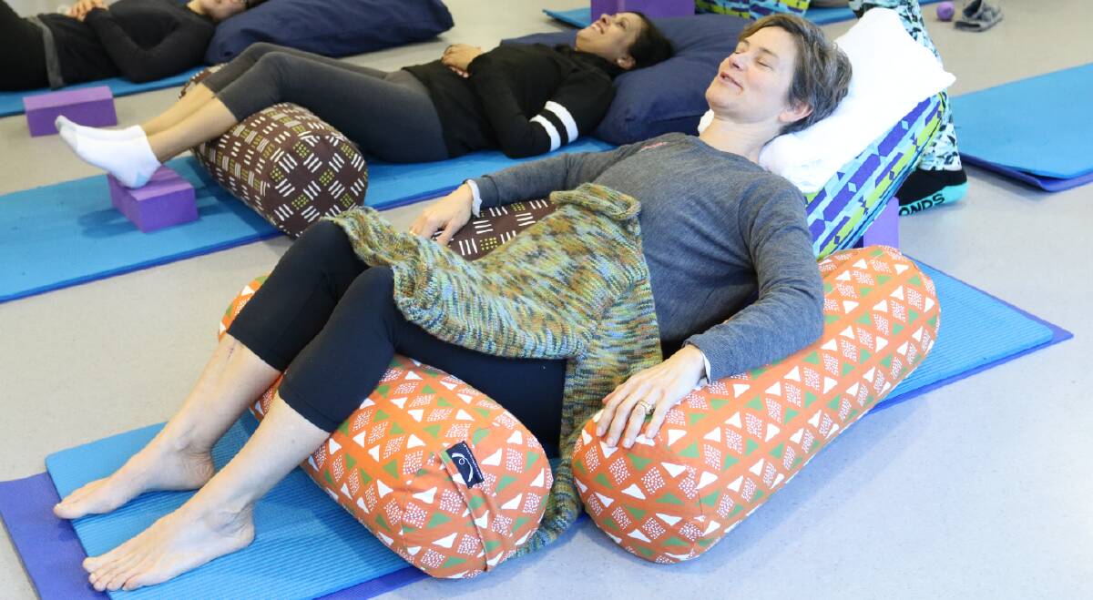 BREATHE EASY: Yoga student Liz enjoys a restorative pose for relaxation in the Lifehouse yoga class.