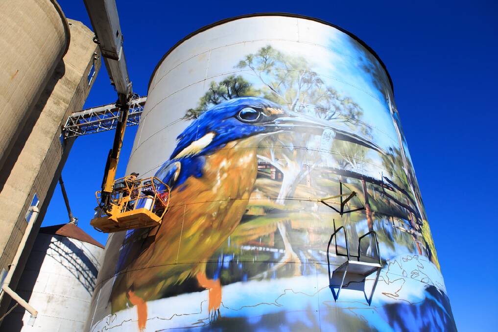 FLIGHT OF FANCY: Mural artist Jimmy DVate at work on his azure kingfisher silo art in Rochester. Photo: graffixcreative.com