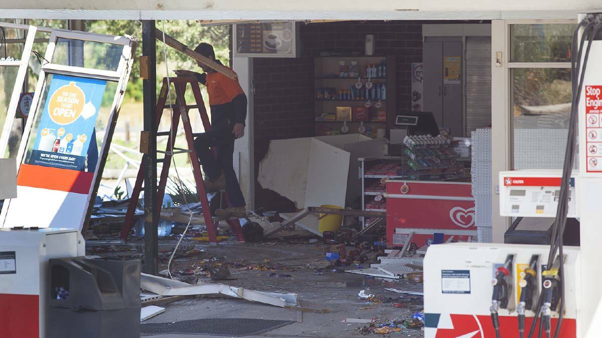 Workers survey the damage left in the wake of a bobcat ram raid at Smythesdale's Caltex service station. Picture: Mark Smith