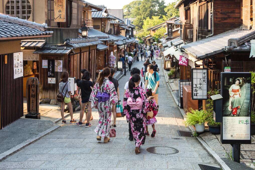 Young women wearing traditional Japanese Kimono walk in the street of Gion, Kyoto old town in Japan. Picture Shutterstock
