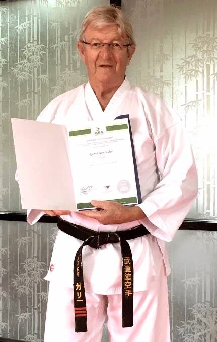 PRIZED STUDENT: Garry with his 2nd Dan certification from the World Shotokan Karate Federation.