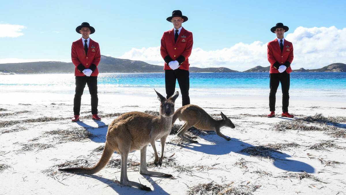 WITH BELLS ON: Cunard's bell boys can't wait to get their toes into Australian sand again.