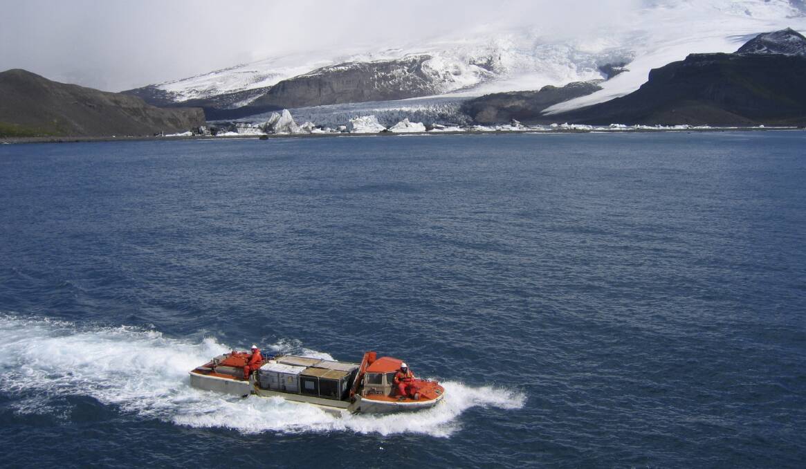 BRAVE NEW WORLD: Australian explorers and scientists have played a key role in shaping what we know about Antarctica. Pictured: A light amphibious resupply cargo vessel transporting gear in February 2004 with Stephenson Glacier in the background, Heard Island, Antarctica. Photo: D.E. Thost courtesy of National Library of Australia. 