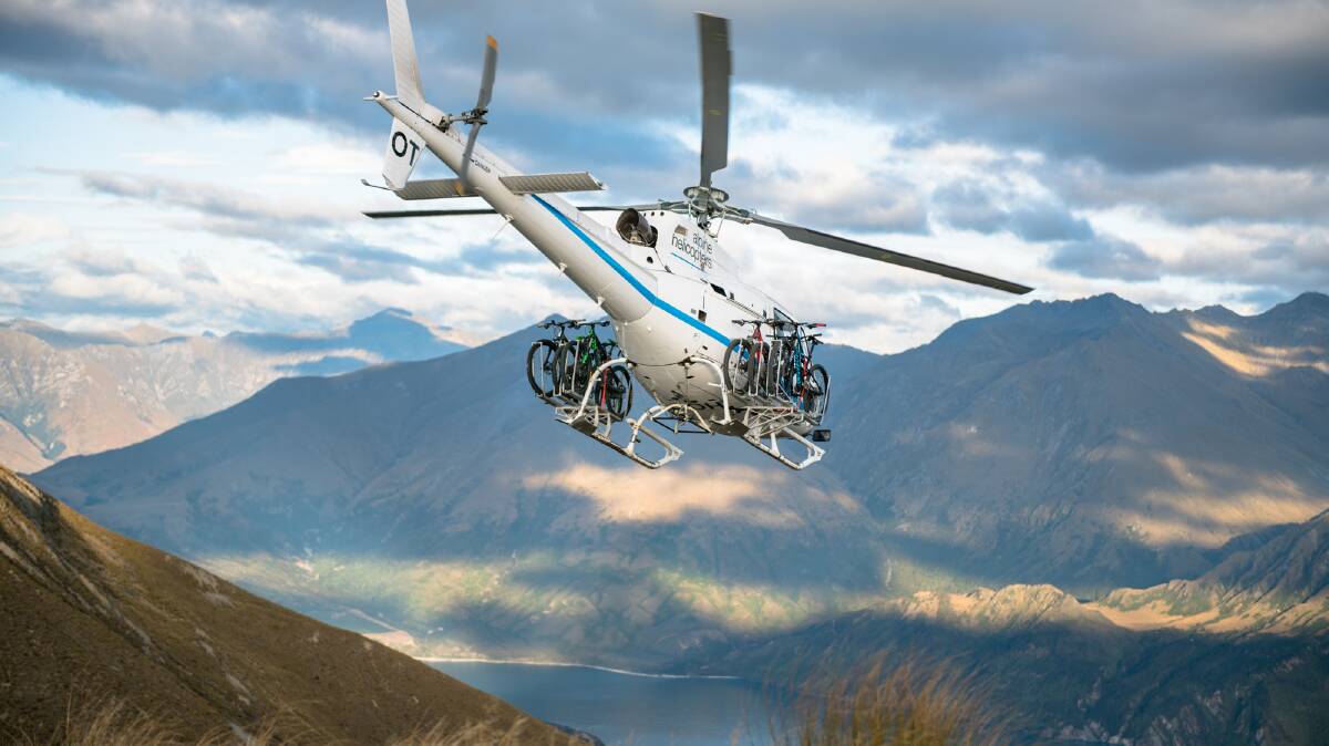 HIGHER GROUND: A Wanaka helicopter transporting e-bikes high above the mountains.Photo: Wanaka Bike Tours.