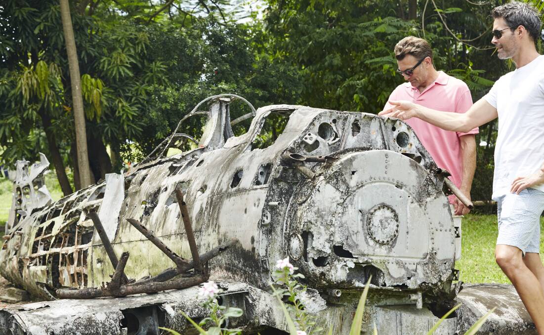 RUST IN PEACE: Expert guide Peter Spring (right) gives the rundown on a wartime aircraft at Rabaul, one of many military relics at the museum there. 