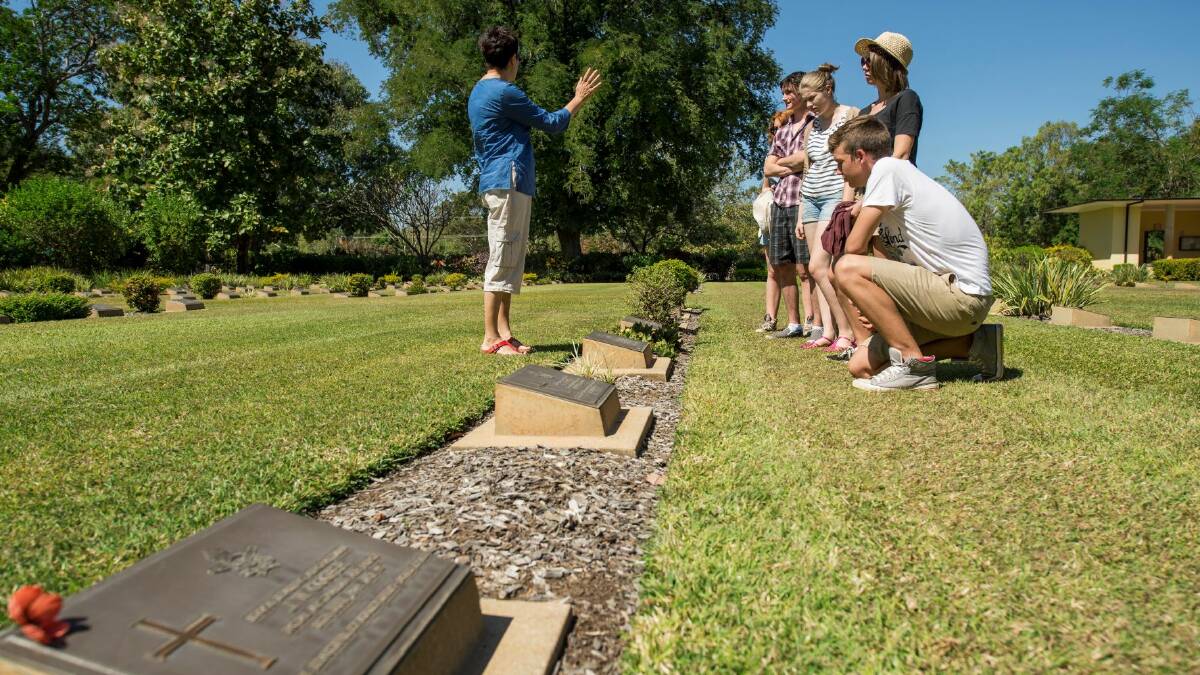 Remembering the fallen: Visitors at Adelaide River War Cemetery reflect on those who died during WWII. Photo: Shaana McNaught/Tourism NT.