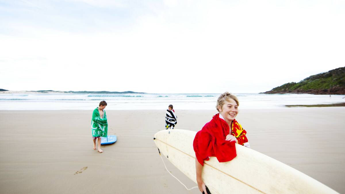 : Children surfing at One Mile Beach in Forster, North Coast