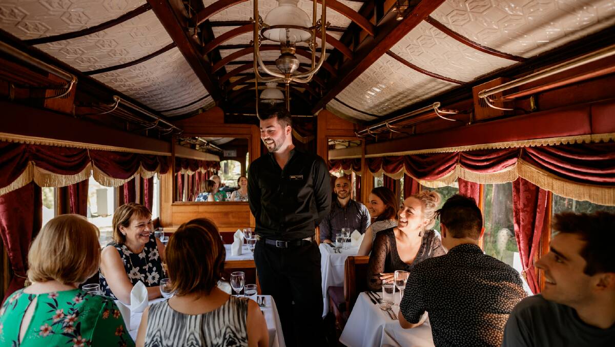 A waiter talks to diners aboard the plush new carriage. Picture supplied by Puffing Billly