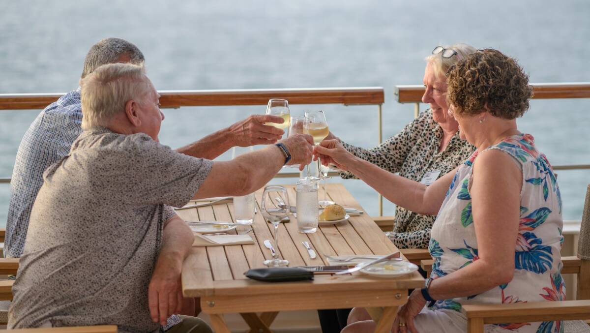 Guests toast being aboard Coral Geographer. Photo: Jeurgen Freund