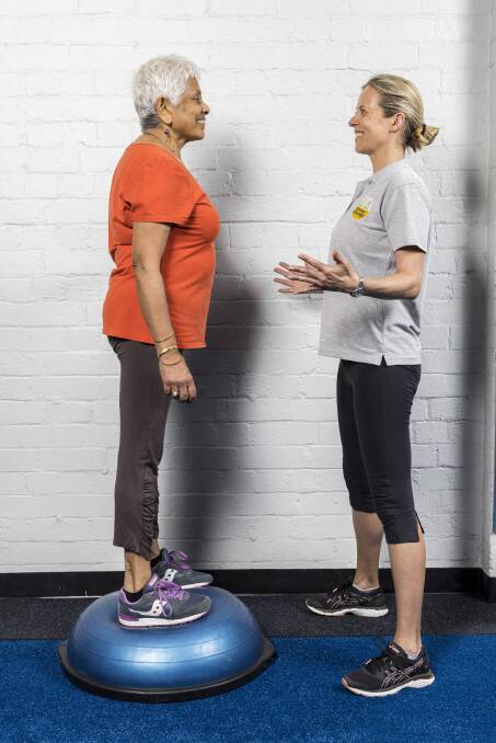 Living Longer living Stronger Coordinator Kamilla Haufort shows Eesa how to perform balance exercise on Bosu.