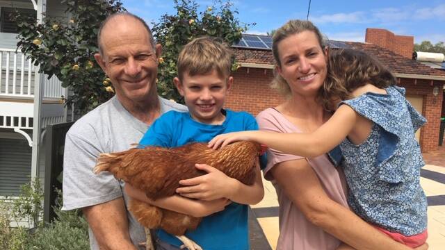 COMMUNITY KINDNESS: Neighbours Geoff Boughton and Constanze Spicer with her children and chook. Photo: Supplied.