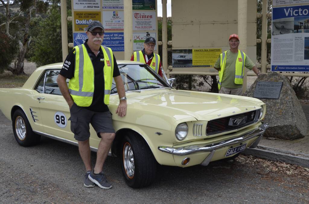 START YOUR ENGINES: Lester alongside his 1966 Mustang with Coffee 'n' Cars organisers Wes and Leith who is standing at the Information Bay by the Grand Prix plaque.