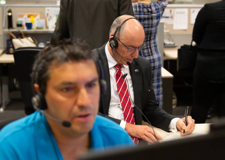 Services Australia staff member Giovacchino Brugnera at the virtual service centre, with Minister Stuart Robert taking notes. Picture: Supplied 