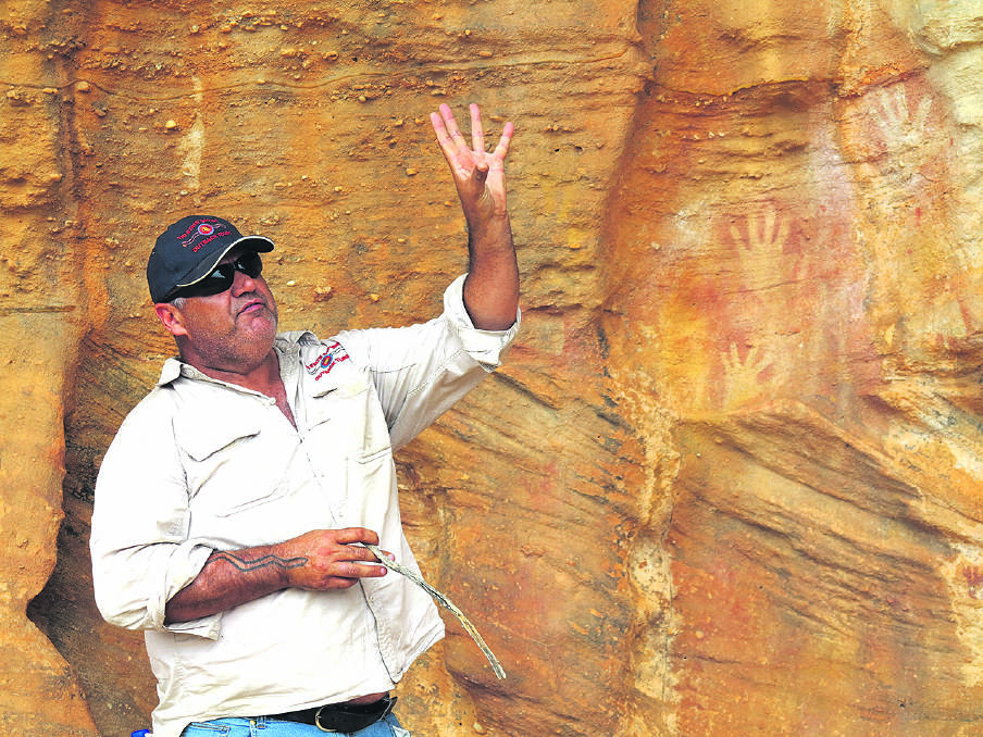 SHARING THEIR KNOWLEDGE – Indigenous guide Mark explains the ancient rock art. Photo: Jo Stewart.