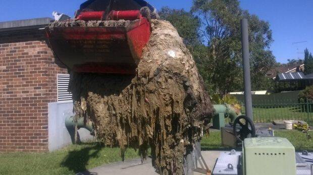 Sydney Water workers at the Shellharbour sewage pumping station cleaning out a blockage of wet wipes also known as a fatberg.  Photo: Sydney Water