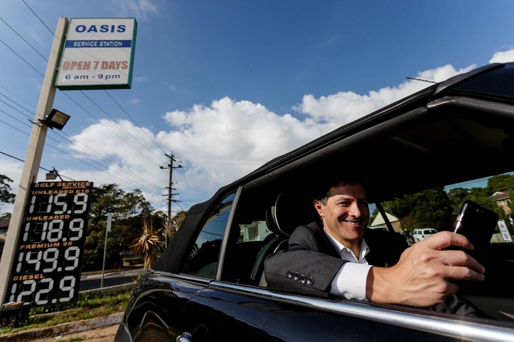 NSW Finance Minister Victor Dominello uses the Fuel Check app at a service station in North Ryde. Photo: Brook Mitchell