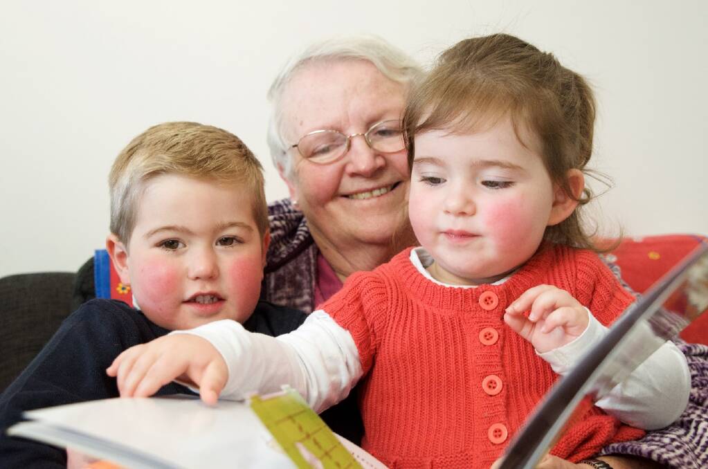 READ ALL ABOUT IT – United Way volunteer, grandmother Vera, reads to “baby bookworms” Luke and Aileen.