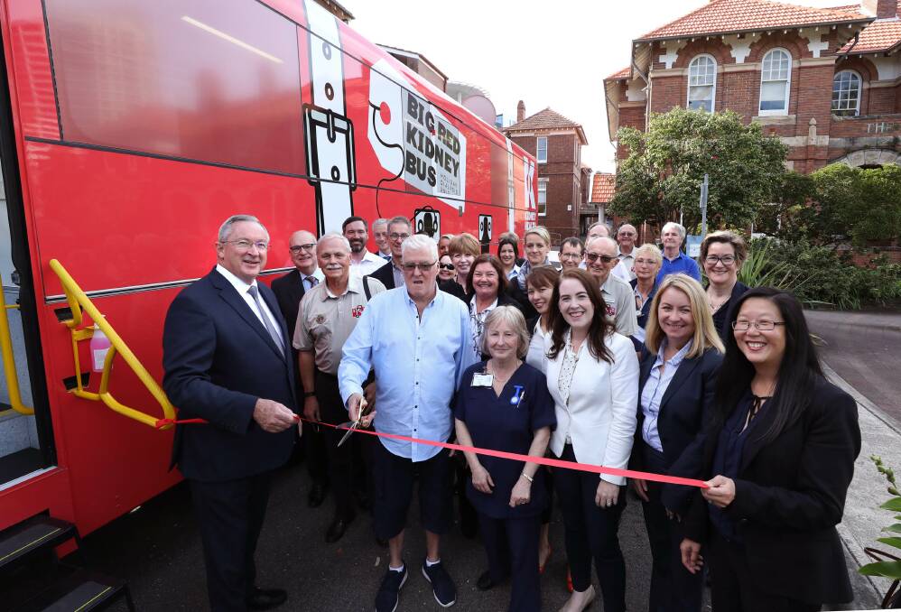 ALL ABOARD – Renal patient Terry Wright cuts the ribbon to launch the Big Red Kidney Bus at Royal North Shore Hospital.