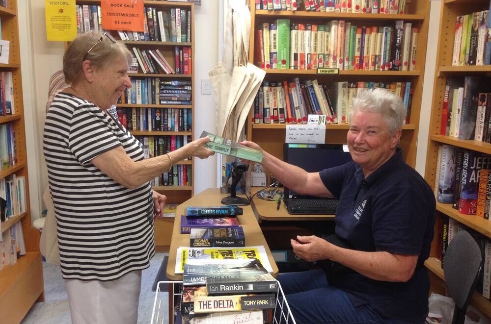 PAGE-TURNERS GALORE – Volunteer June Skinner (right) serves a customer at the Guilderton Community Library.