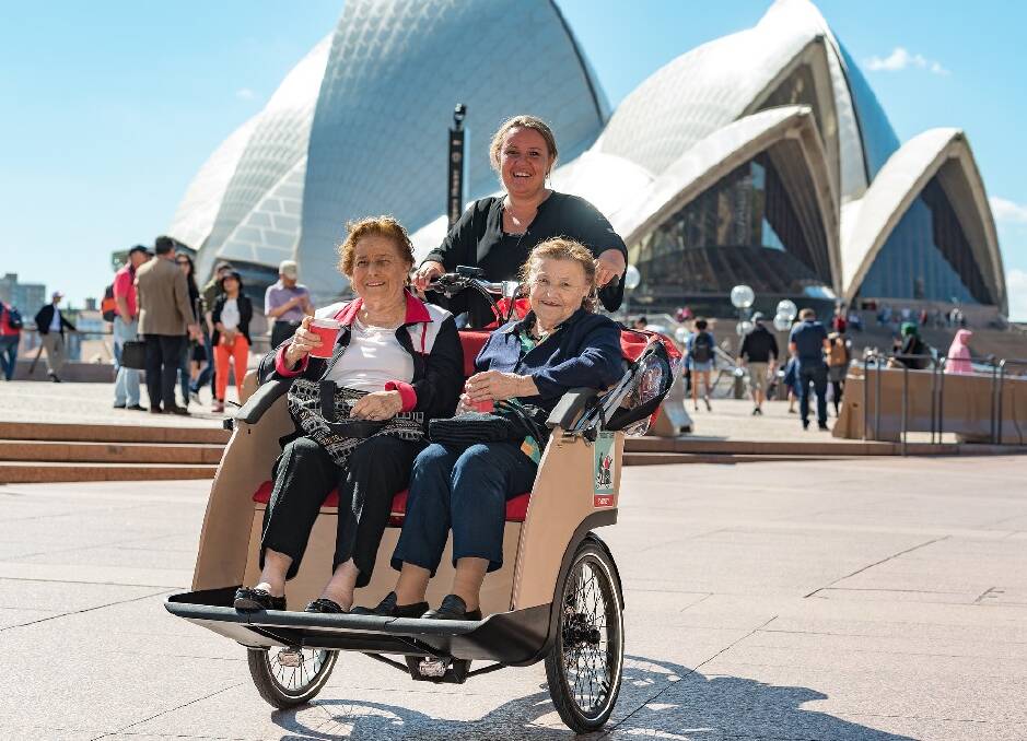 CYCLE OF LIFE – Sisters Aida Hastings, 89 (left), and Pat Crestani, 90, enjoy a spin at the Sydney Opera House with Cycling Without Age  co-founder Dorthe Pedersen.  Photo: John Slaytor