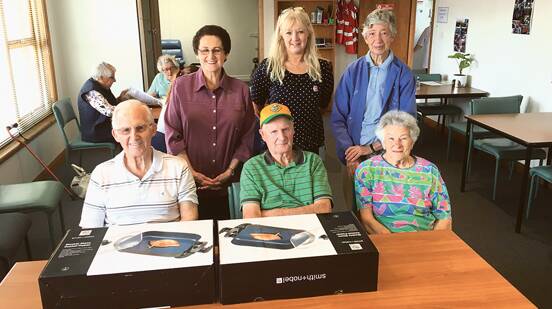 HERE'S COOKING AT YOU – SEC Care day centre co-ordinator Kathy Mass (centre back row) with members of Midway Point Indoor Bowling Club (front row, from left) Doug, Ralph, Dawn; (back row) Dianne and Helen at the Sorell Day Centre with the donated frying pans.
