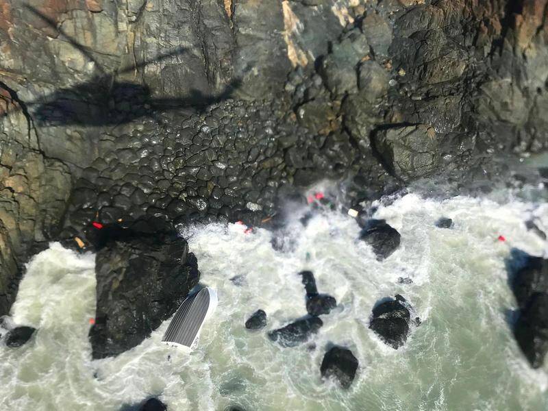 A bobbing blue esky has helped rescuers find two fishermen at the base of a cliff in Queensland.