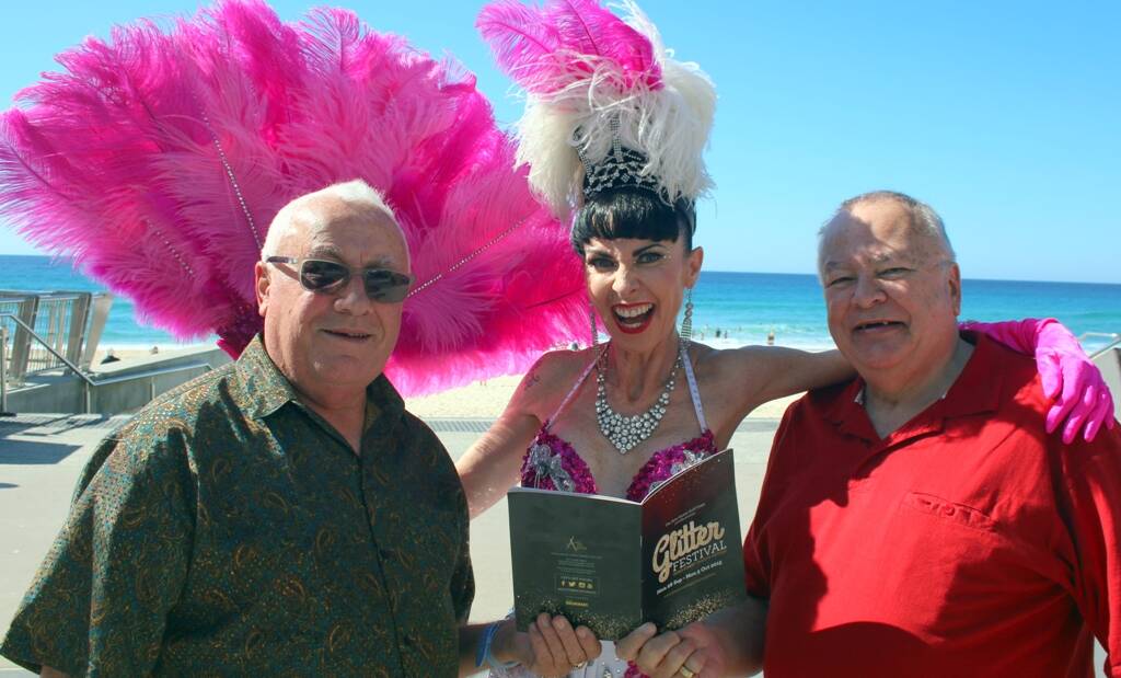 CELEBRATING DIVERSITY –  Gold Coast residents and arts lovers Ross Smith and Roger McKenzie check out the Glitter Festival program with Fleur Talicious.