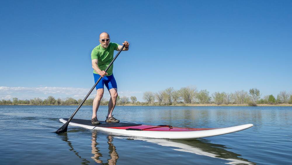 Try stand-up paddleboarding. Photo: Shutterstock.
