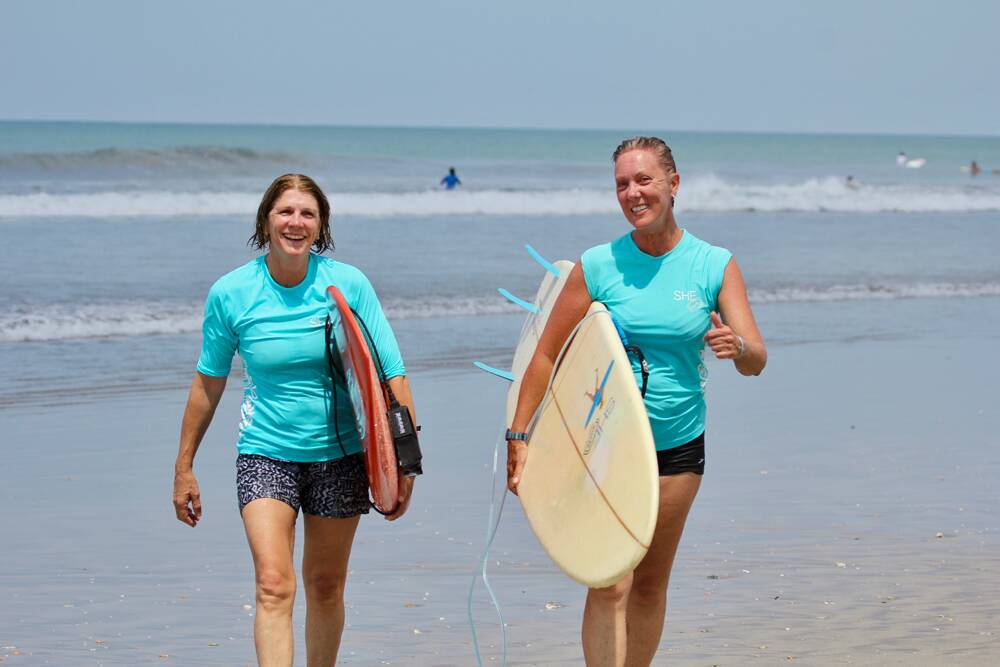 SHE surfs' Suzanne Hart (right) with a guest after a surf lesson.