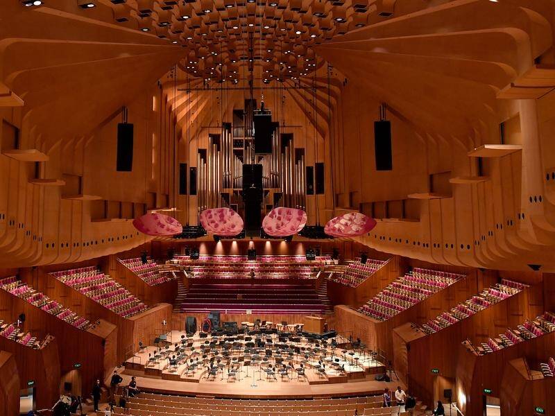 Fuschia-hued "petal" acoustic reflectors are visible in the Concert Hall at the Sydney Opera House.