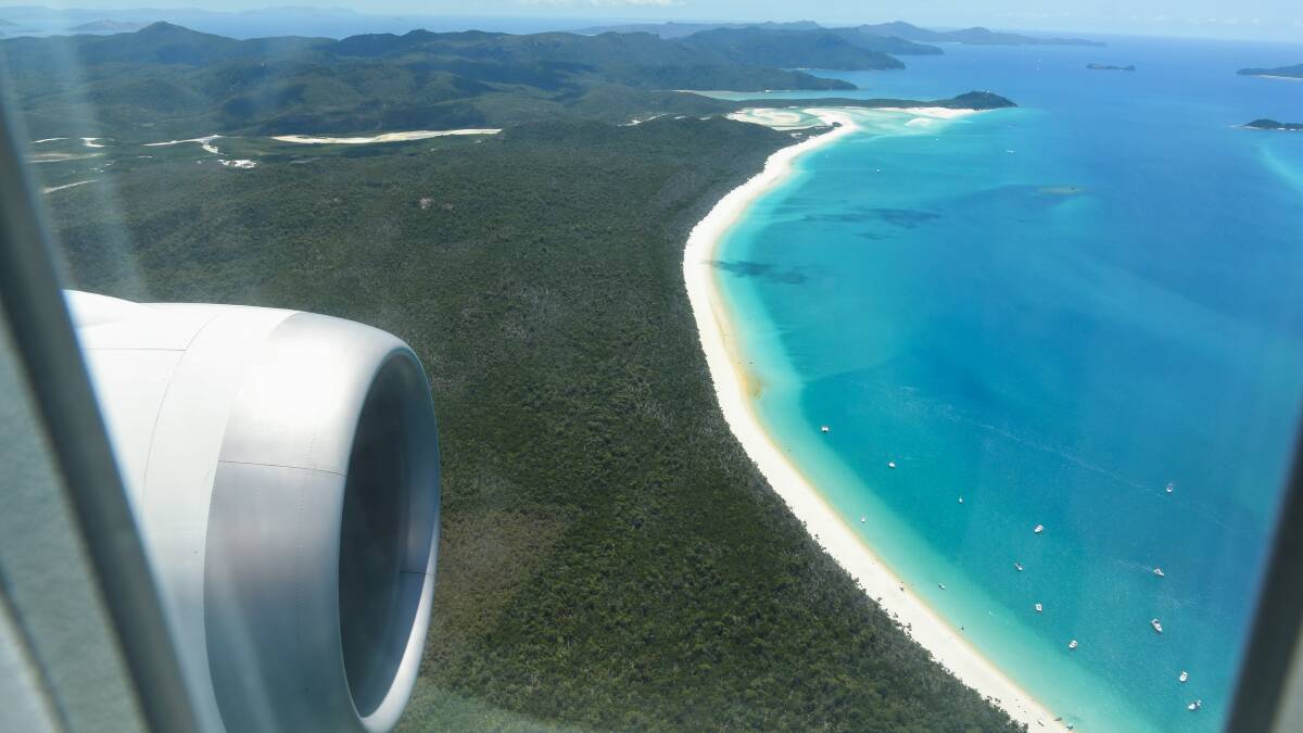 A Qantas flight flies over Whitehaven Beach at Queensland's Whitsunday Islands. Picture: Getty Images