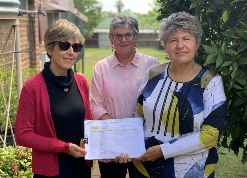 HOPE: Gulgong residents Kathryn Pearson, Kitty Eggerking and Sharelle Fellows holding the paper petition which has been signed more than 1600 times from residents and supporters of the call. Photo: Benjamin Palmer