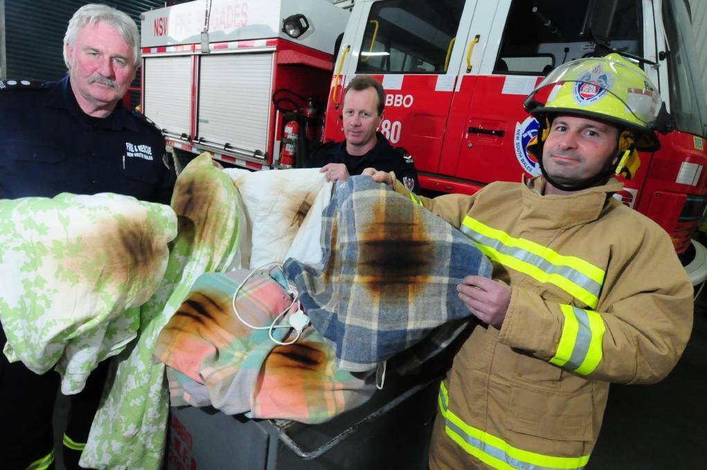 CLOSE CALL: Station Officer Chris Sanders and firefighters Matt Knudsen and Graeme Combridge show an electric blanket that was seconds away from ignition. Photo: LOUISE DONGES