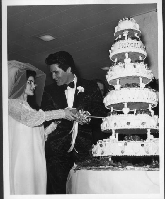 Elvis and Priscilla cut their wedding cake.